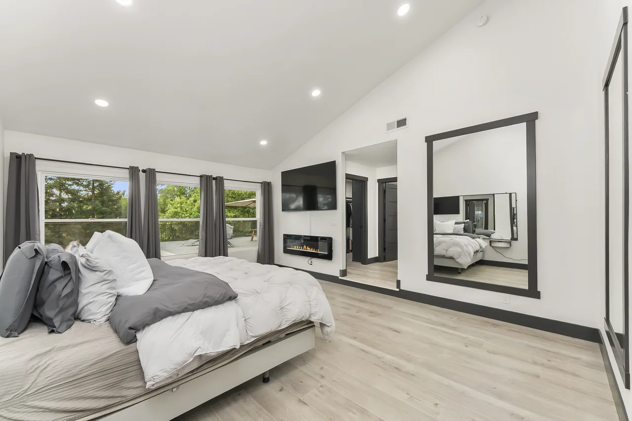 Vaulted bedroom with fireplace and large mirror
