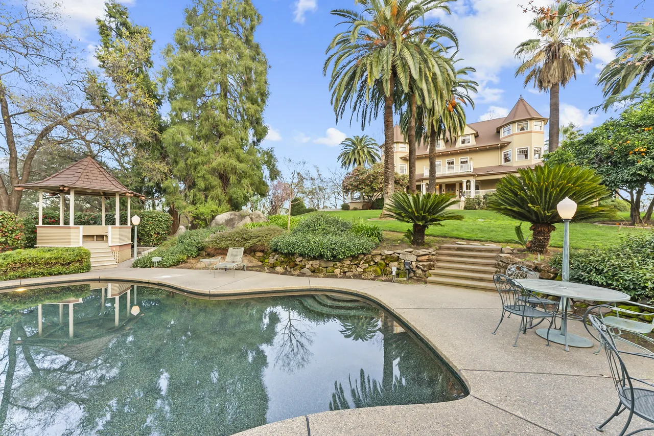 Victorian Queen Anne mansion behind pool